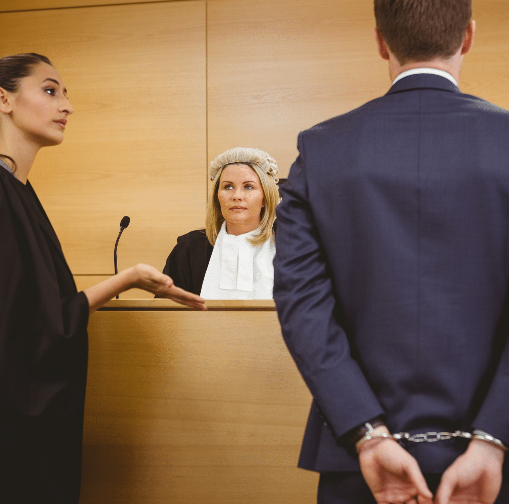 criminal defence lawyer with judge and client in handcuffs in court
