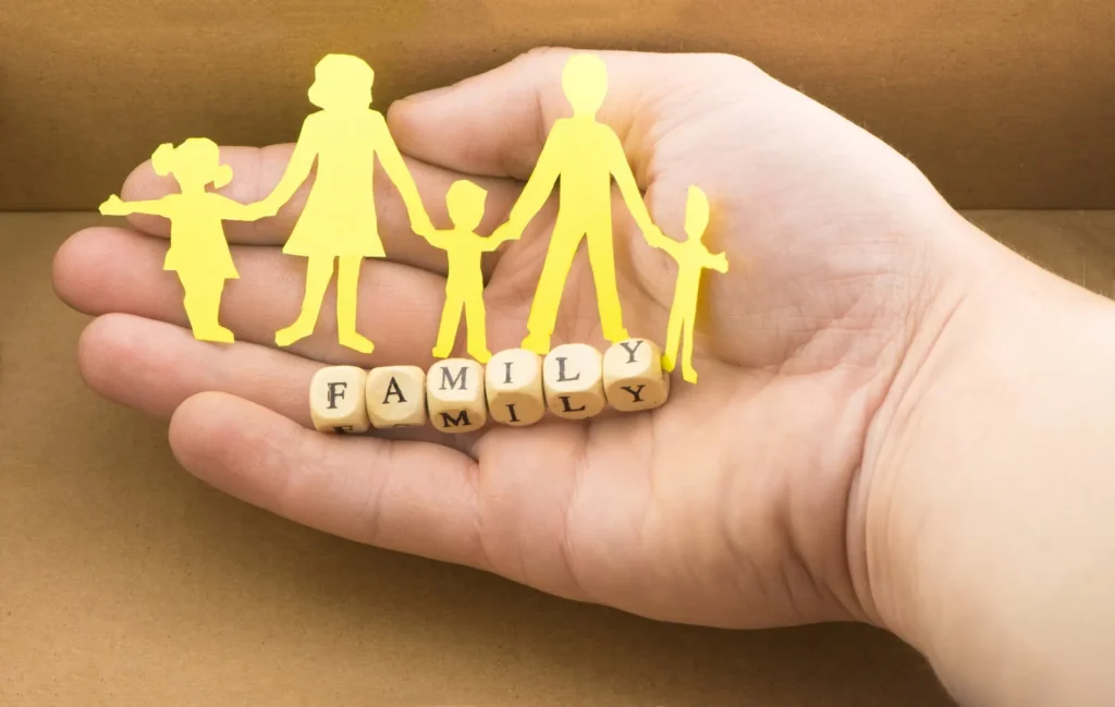Paper cut-out family held in a hand with the word family – family lawyers Melbourne