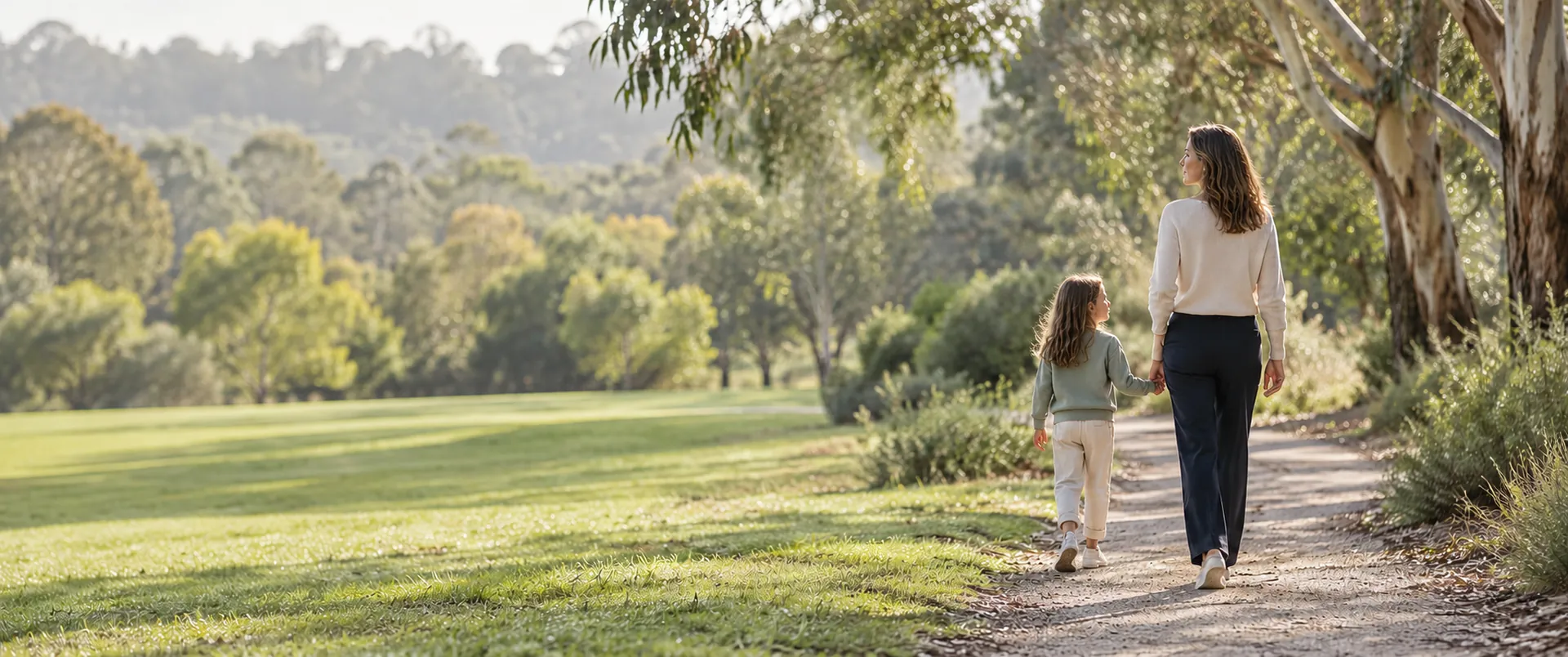 Mother and daughter walking hand in hand through eucalyptus trees – Shamac Lawyers, family lawyers Melbourne
